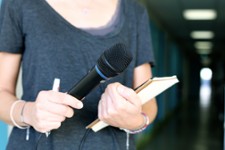 Journaliste tenant un micro et un bloc-note